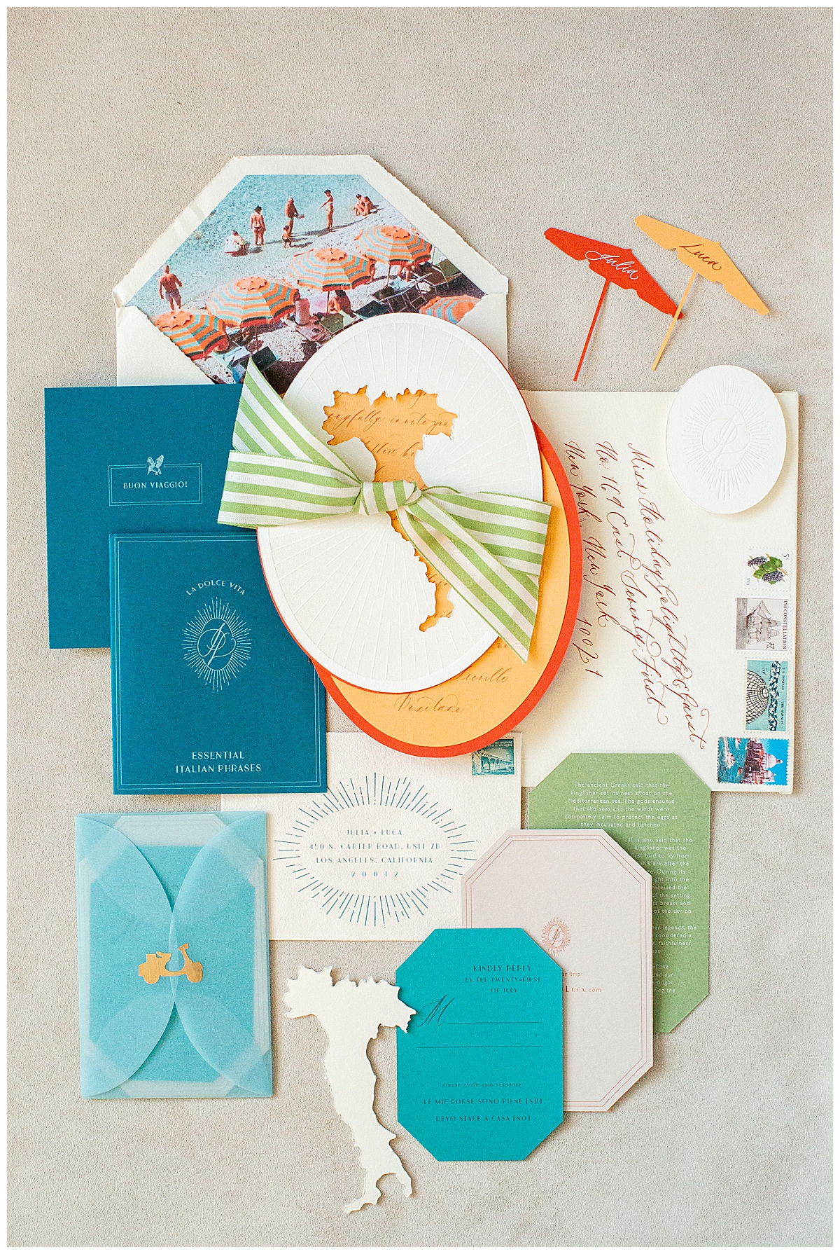 Blue, green, orange and yellow beach themed stationery suite is laid on a table. 