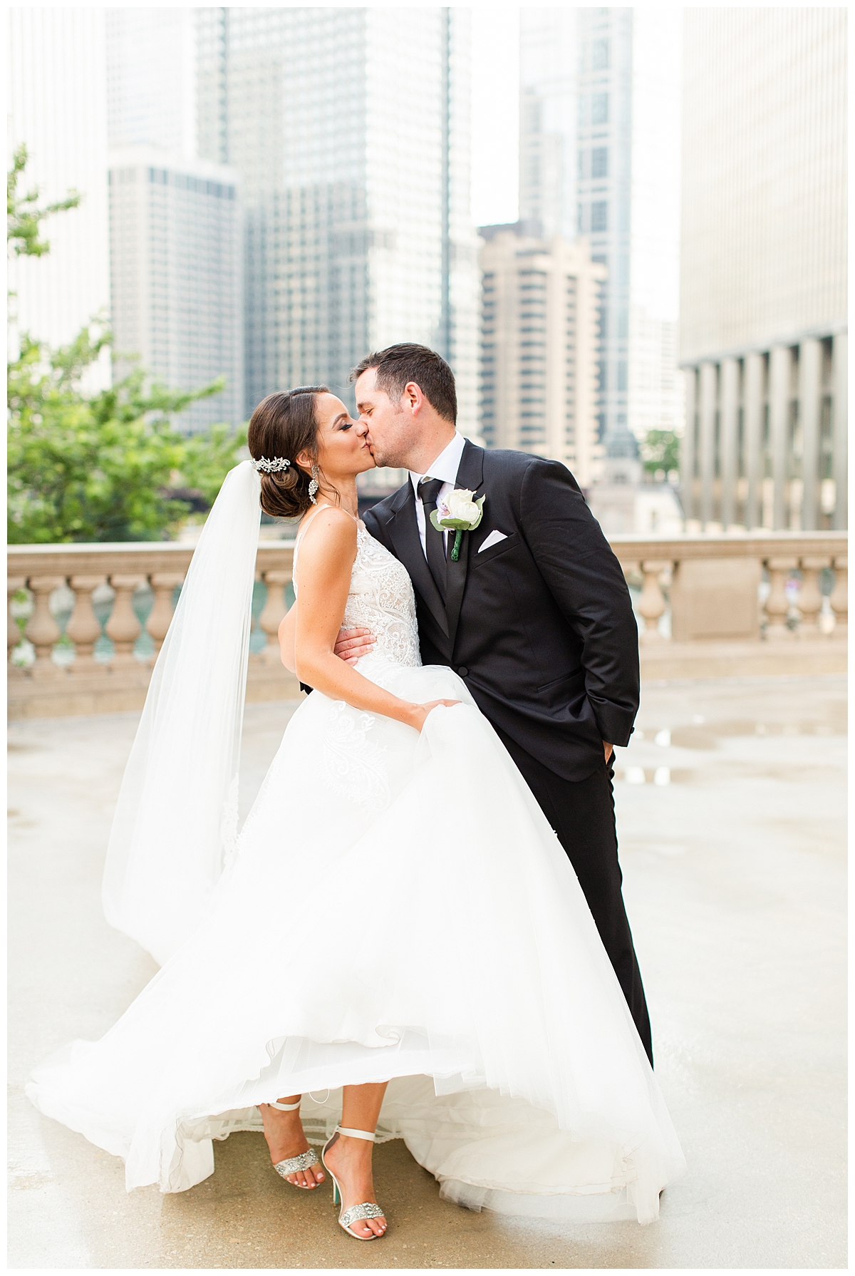 A bride and groom kiss in a wedding portrait at the Wrigley Building in Chicago.