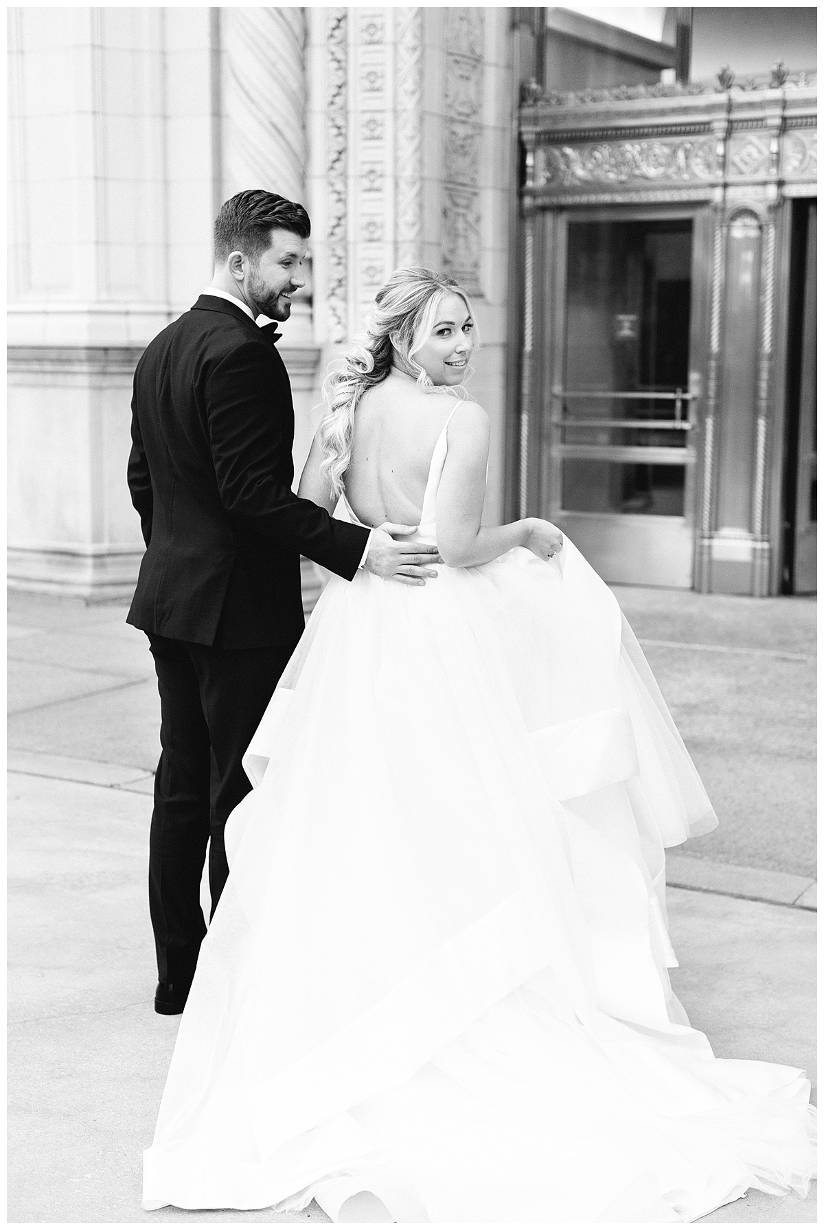 A bride and groom shine in this black and white portrait outside of the Wrigley building in Chicago. 