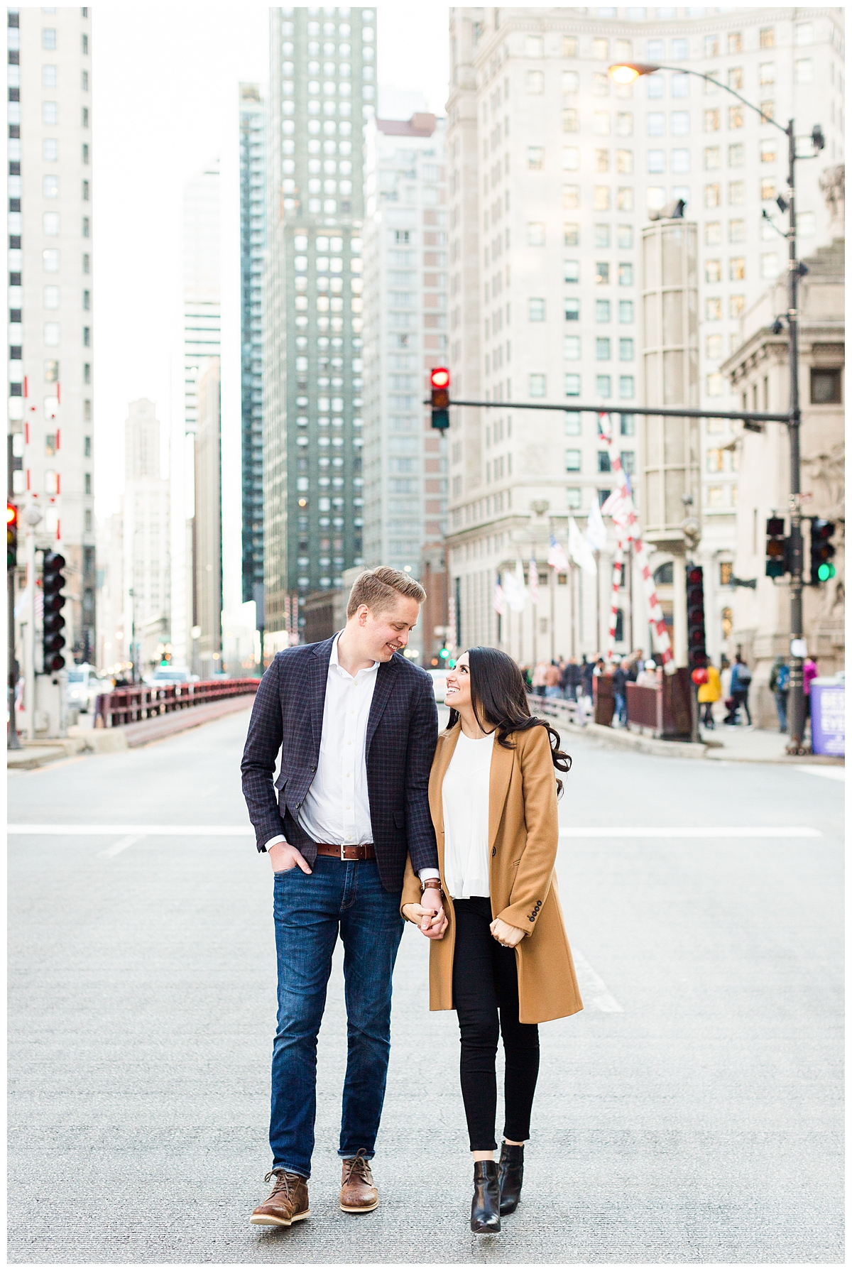 A couple walk in downtown Chicago near the Wrigley building in this engagement portrait. 