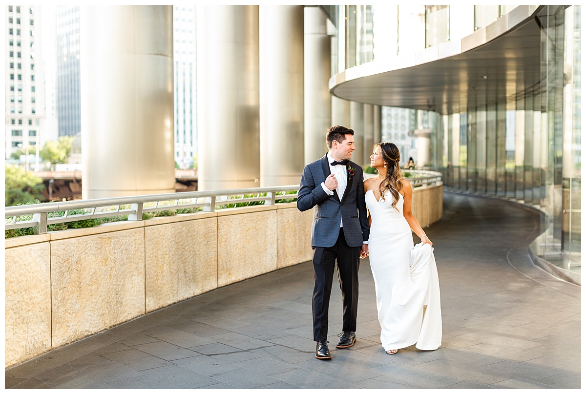 This portrait is of a bride and groom. It is taken at dusk outside of the Wrigley building in chicago. 