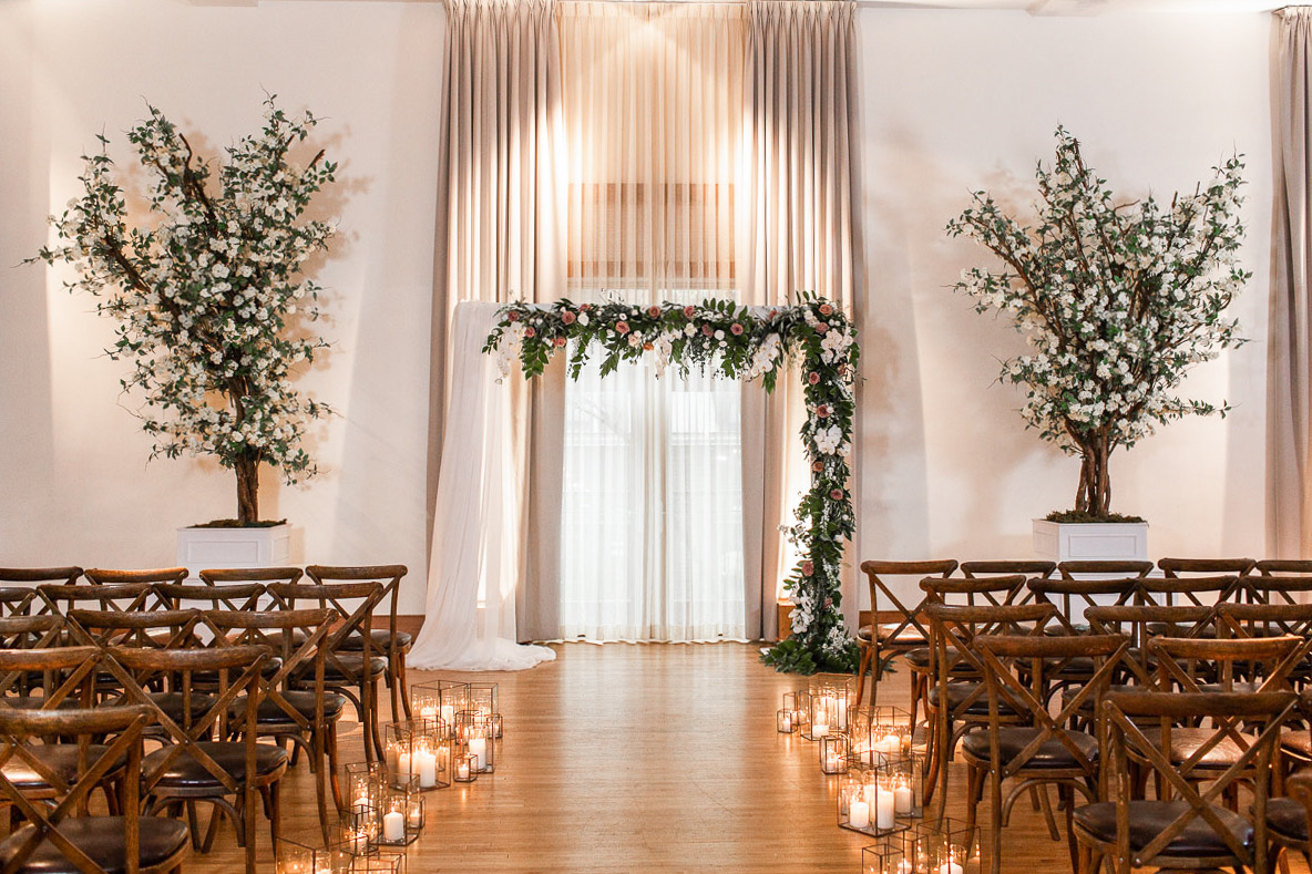 The Ivy Room in Chicago is set up for a wedding with brown wooden chairs and a floral altar. 