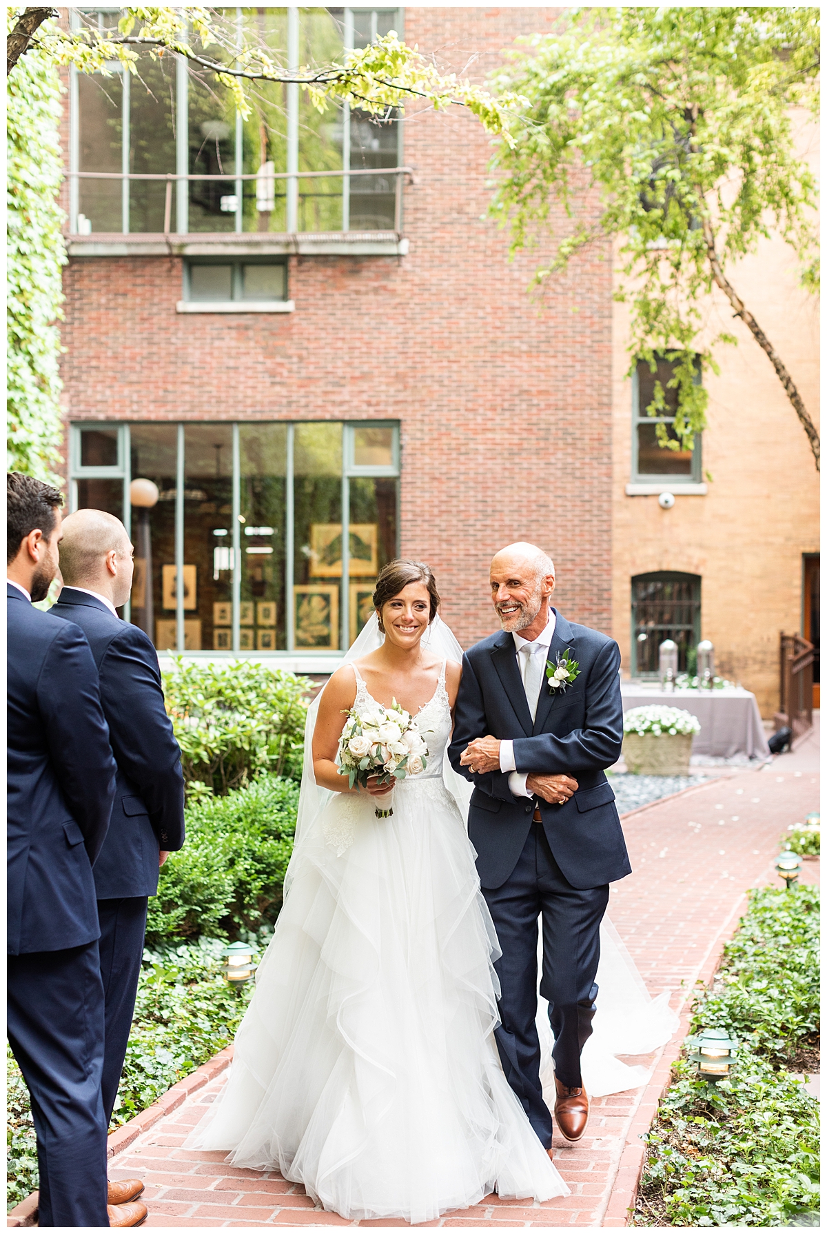The bride and her father walk down the aisle in the courtyard at the Ivy Room in Chicago. 
