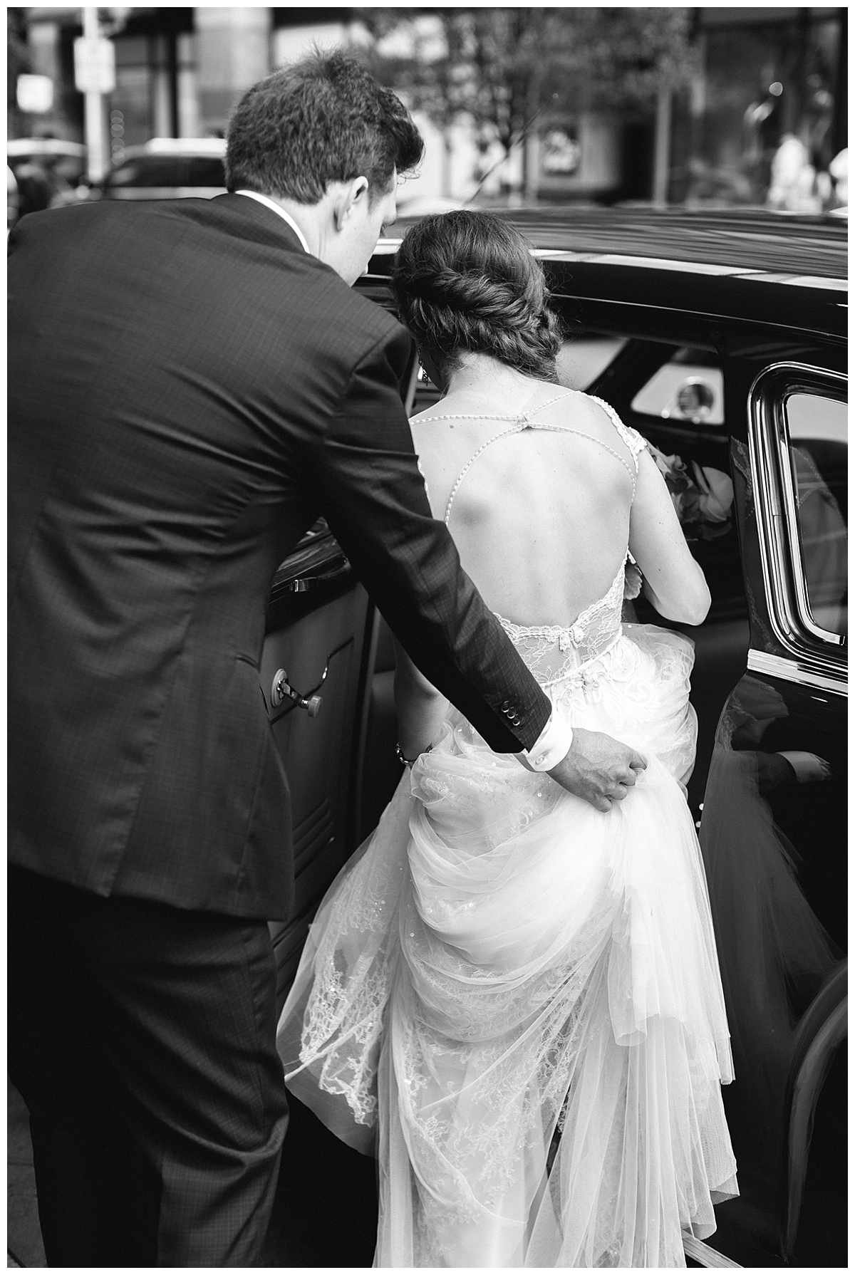 A groom helps his bride in the car 