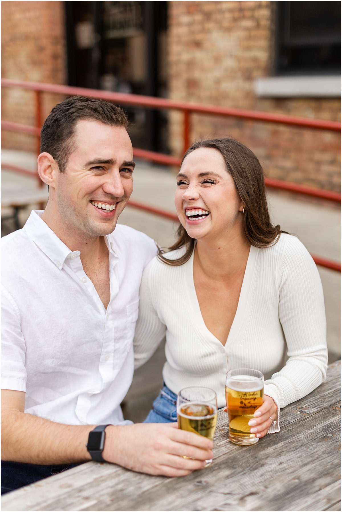 couple laugh during Chicago Engagement Session at Local Brewery