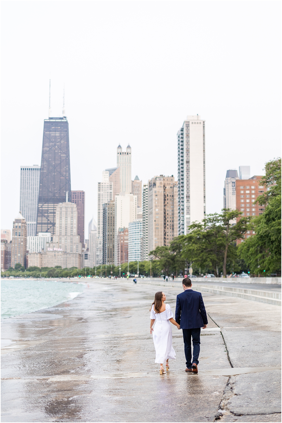 engaged couple walk down North Avenue beach in Chicago holding hands
