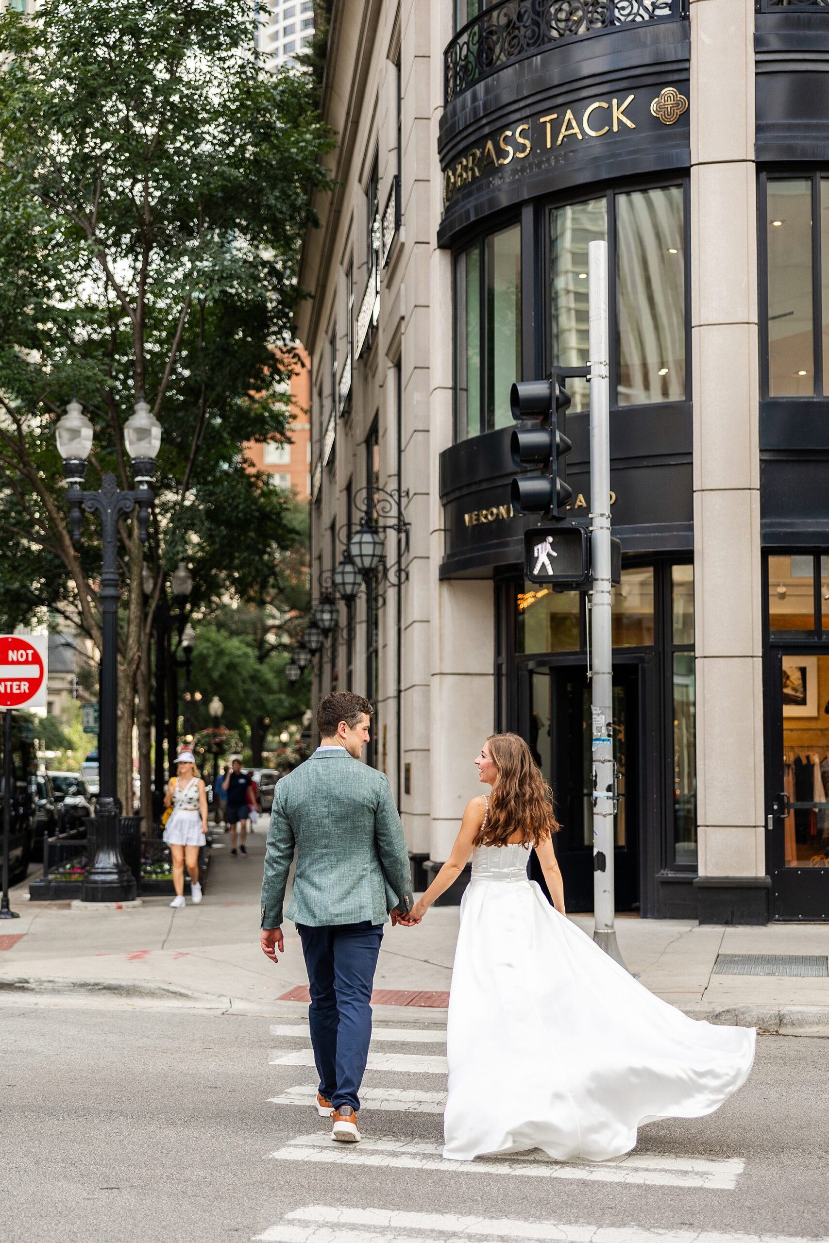 bride and groom walk across street in Gold Coast Chicago