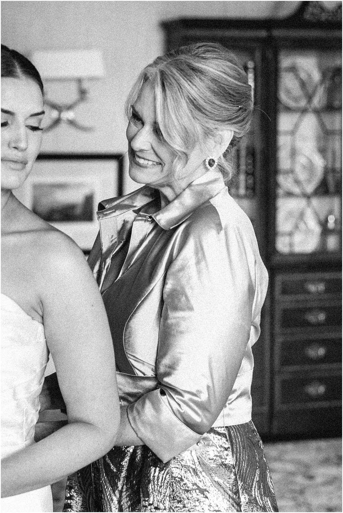 mother helping bride in dress
