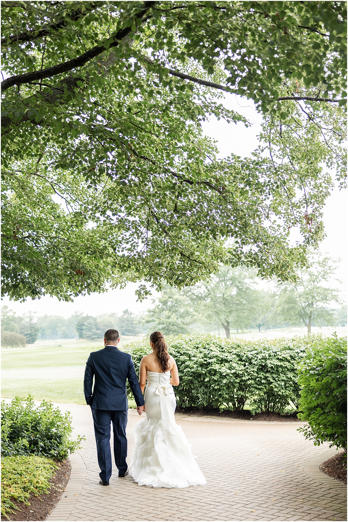 bride and groom walk the scenic grounds of Sunset Ridge Country Club
