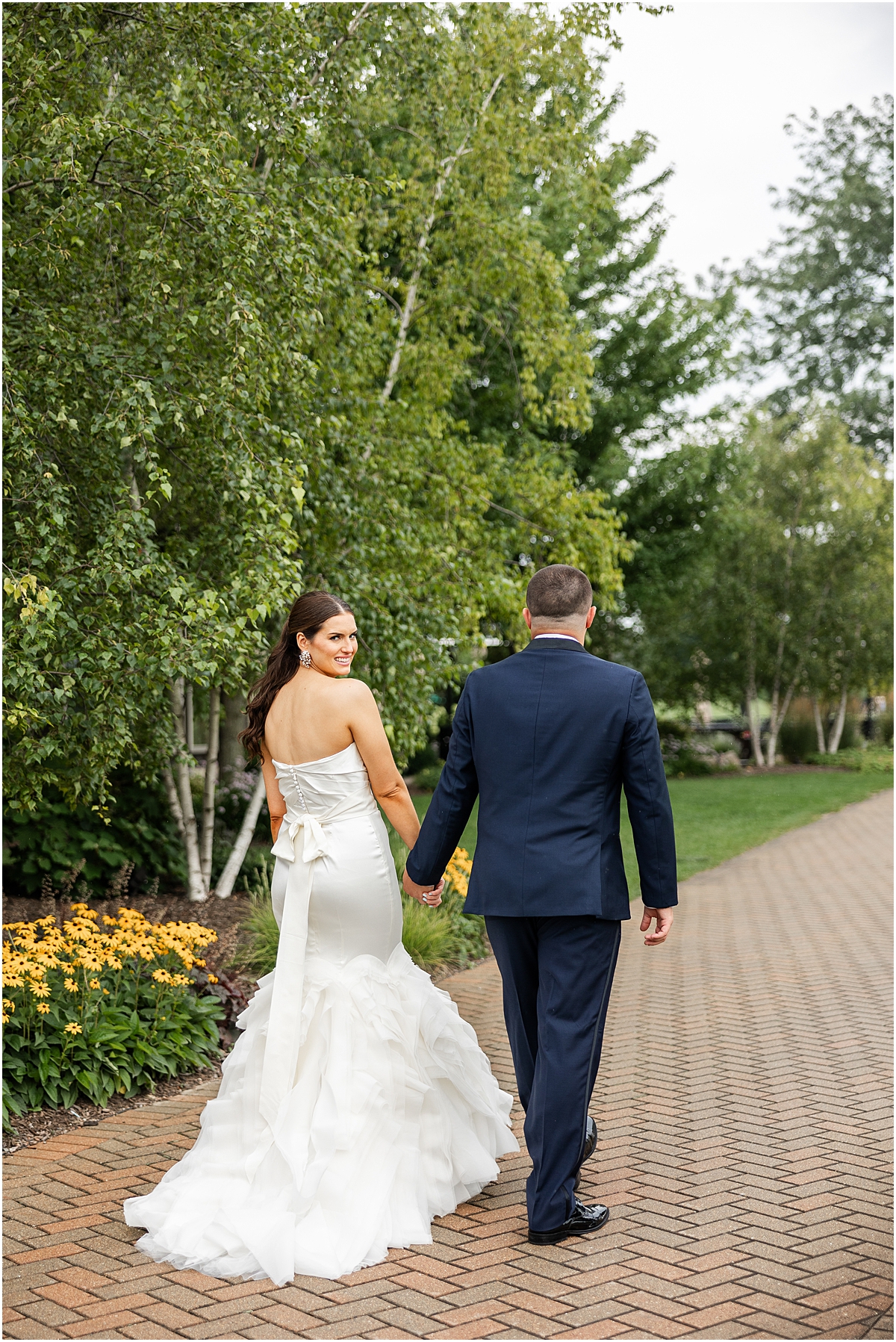 bride and groom walk around the pond at Sunset Ridge Country Club