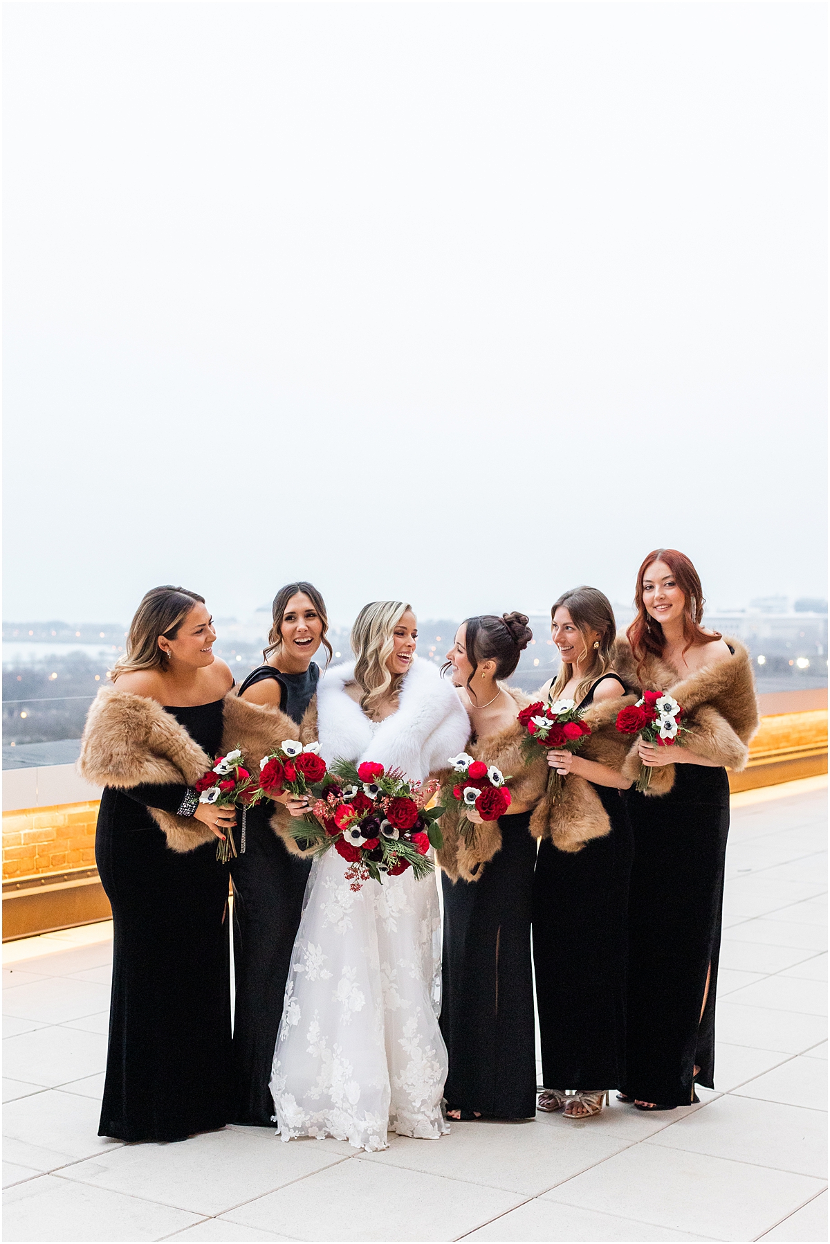 bride in white fur shawl with bridesmaids in black dresses and fur shawls from Chicago Club Winter Wedding