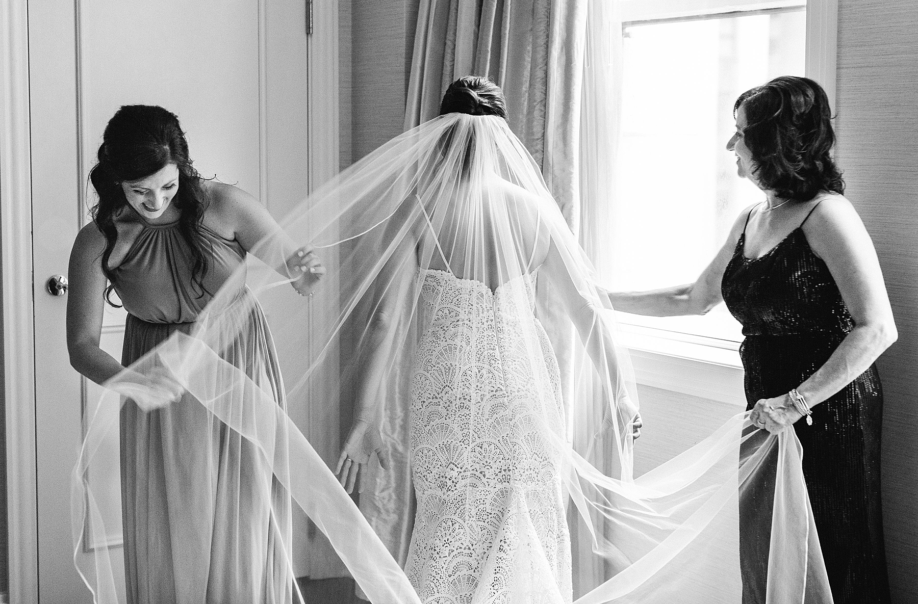 bridesmaids helping bride with veil 