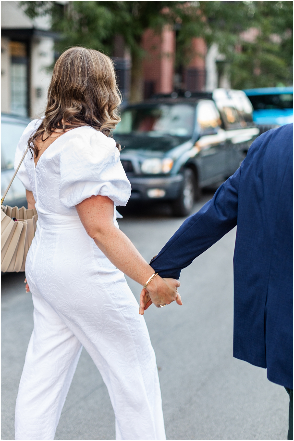 engaged couple hold hands as they walk through Wicker Park neighborhood