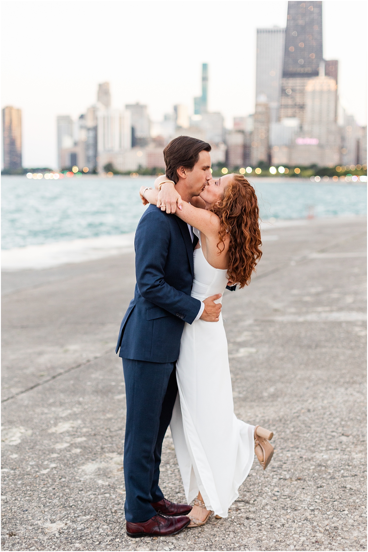 newly engaged couple kiss during engagement session at Chicago's North Avenue Beach 