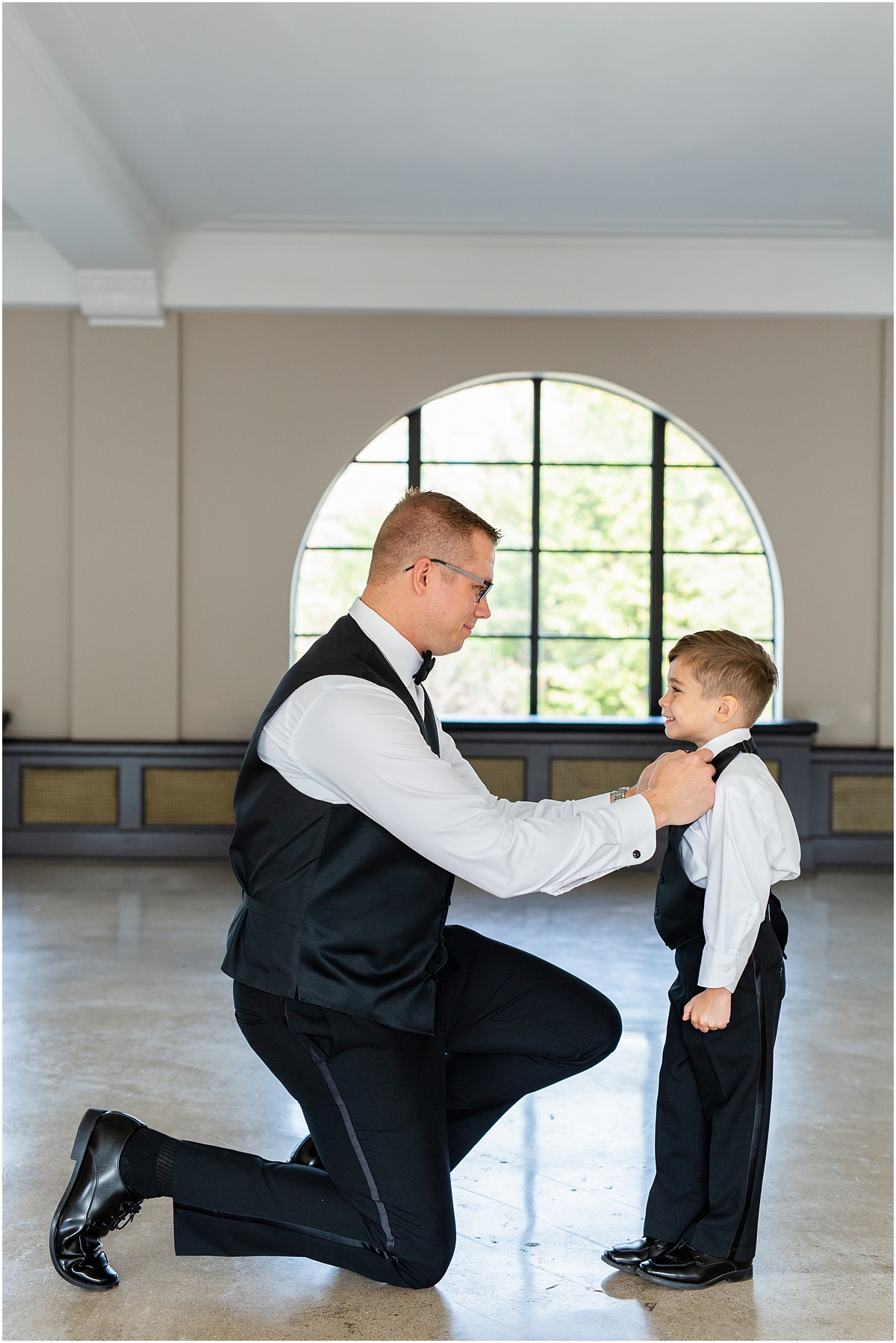 groom helping ring bearer with bowtie