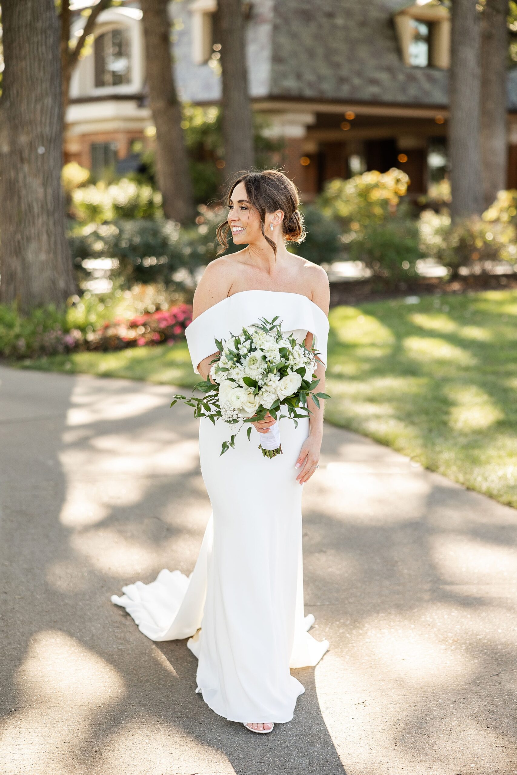 bride in off shoulder wedding gown holding classic bridal bouquet