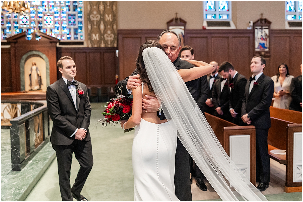 father hugs bride and gives her hand to groom