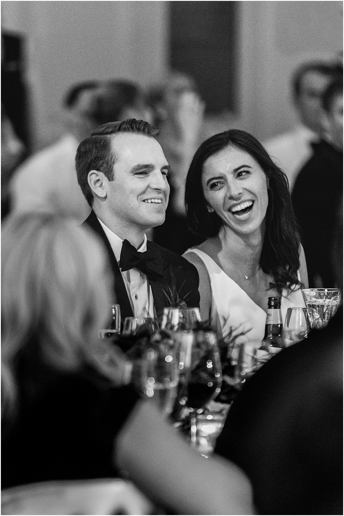 newlyweds laugh during wedding toasts at Chicago wedding reception at Four Seasons Hotel  
