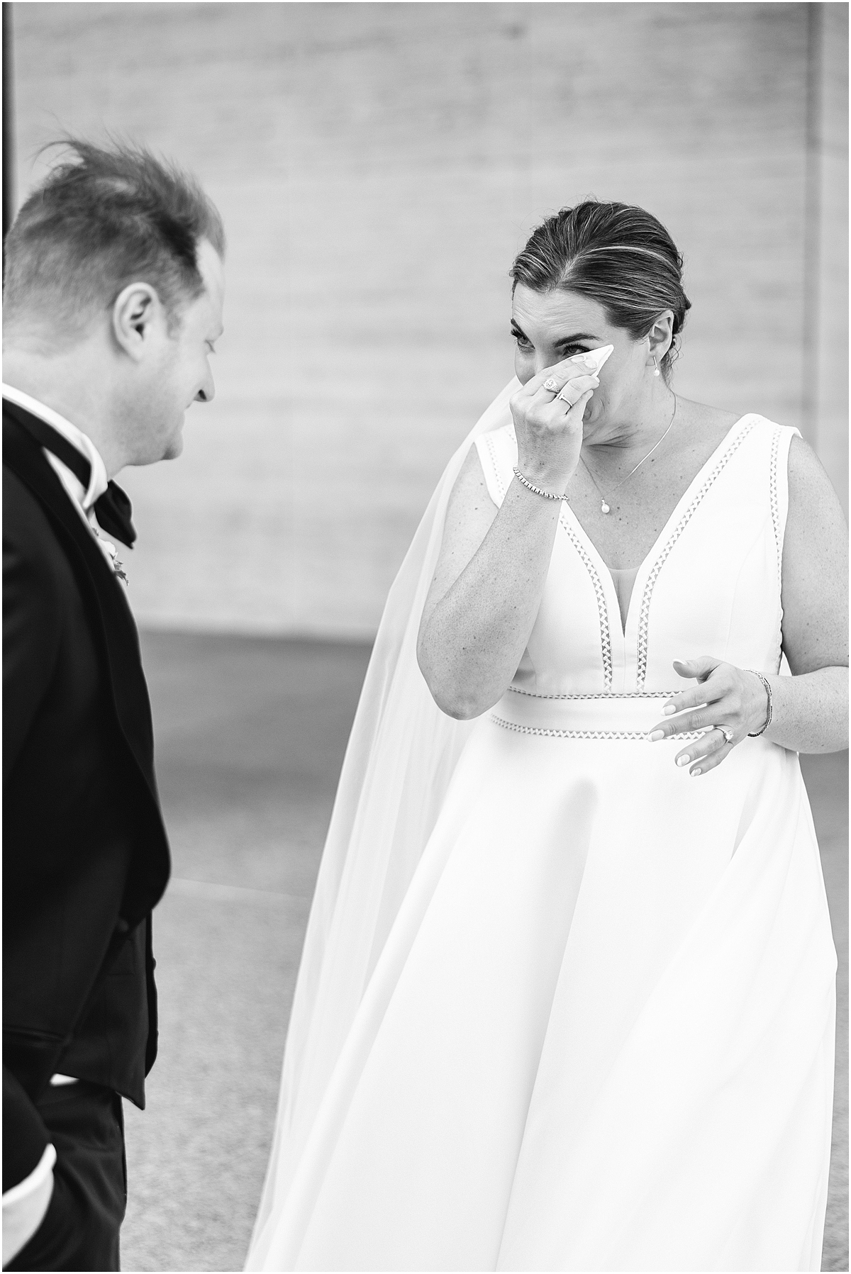 bride wipes away tears during emotional first look
