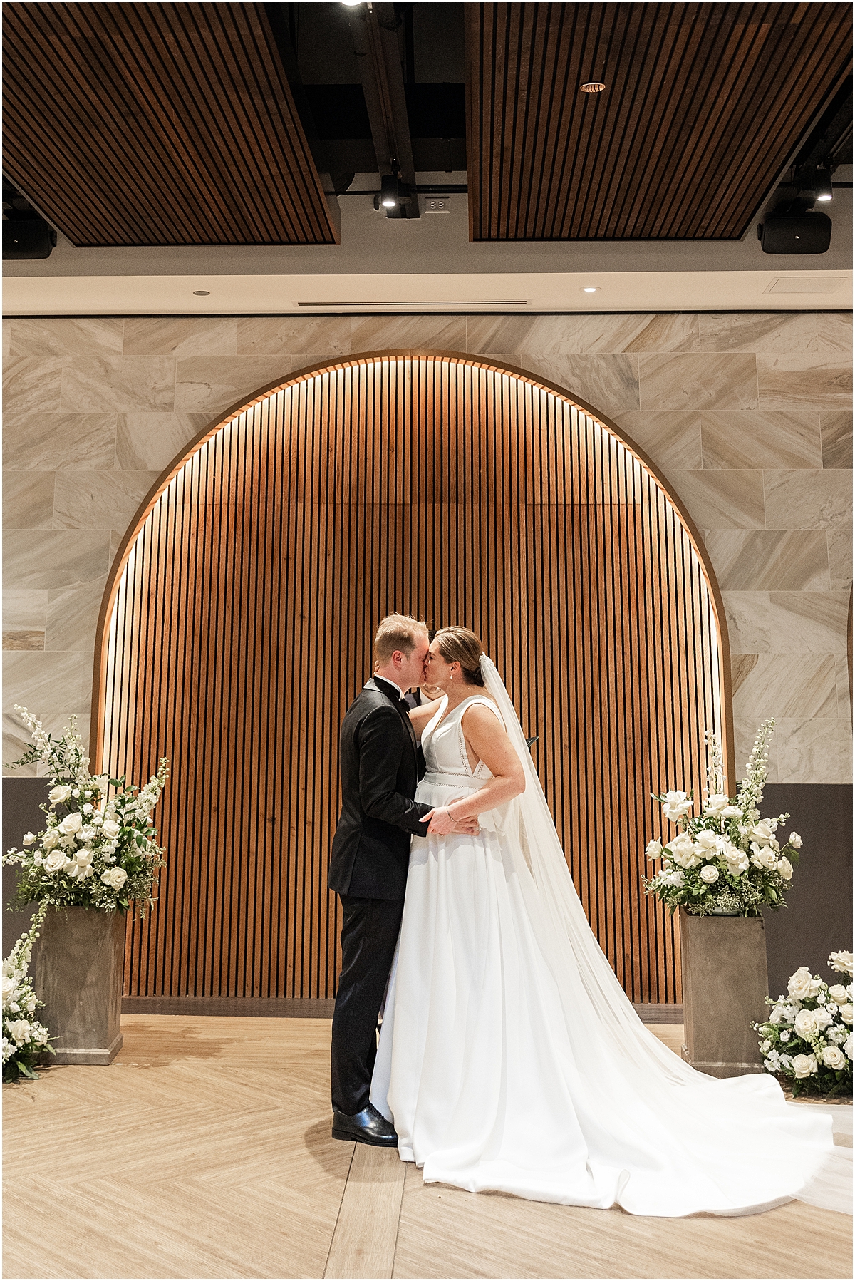 bride and groom kiss at wedding ceremony