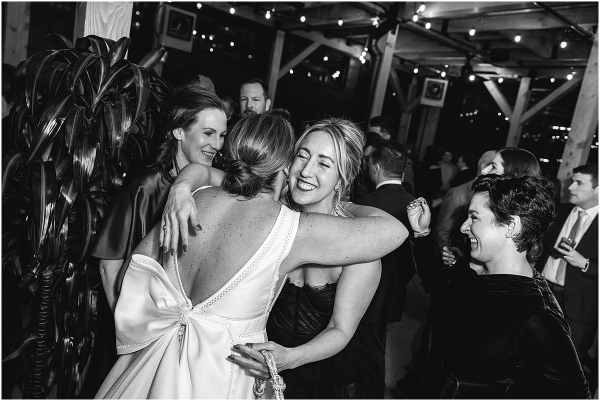 bride hugs guest at wedding reception