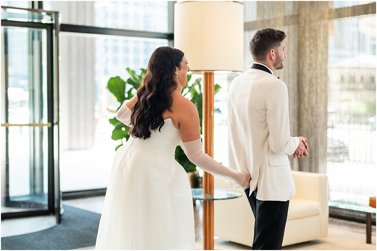 humorous moment of bride pinching groom's butt to get his attention during first look