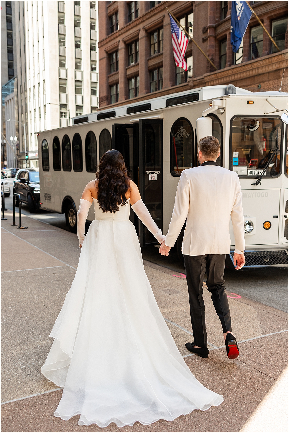 bride and groom walk down Chicago street holding hands