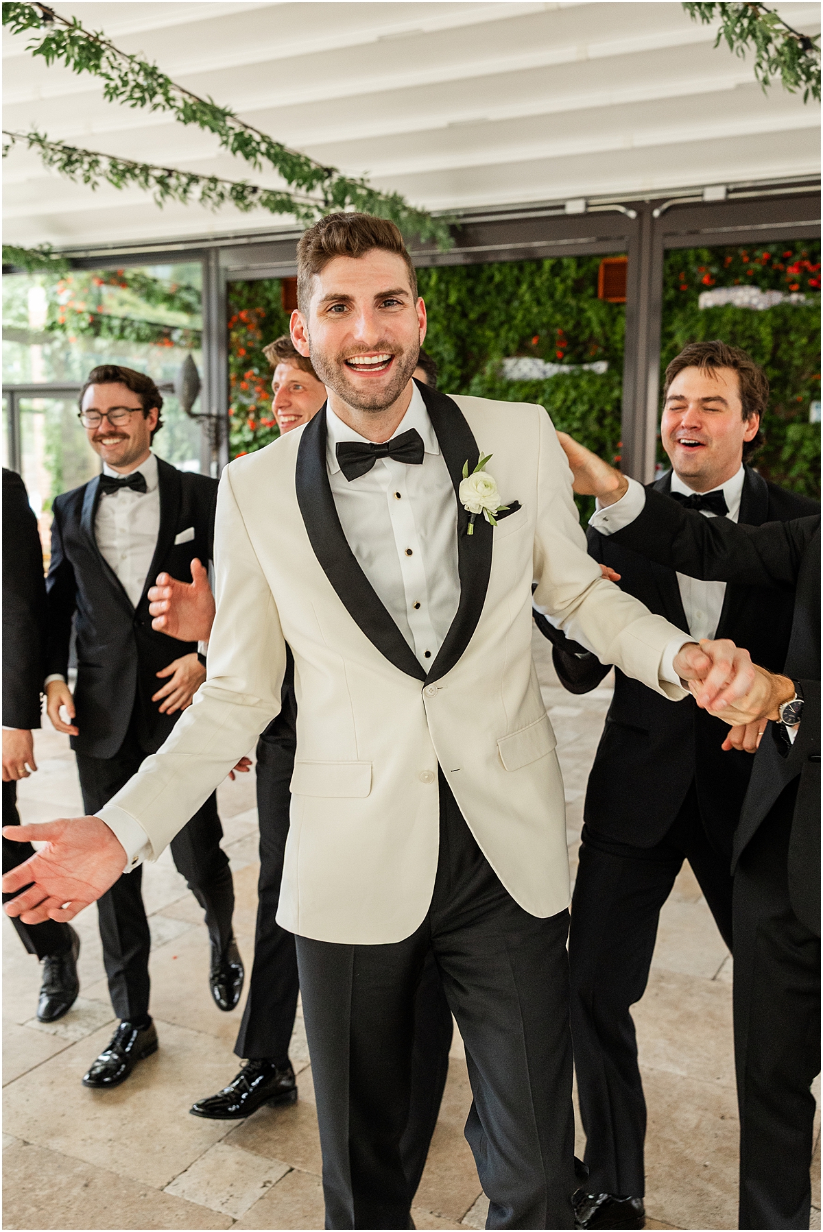 groom in white tux with groomsmen in black tuxes