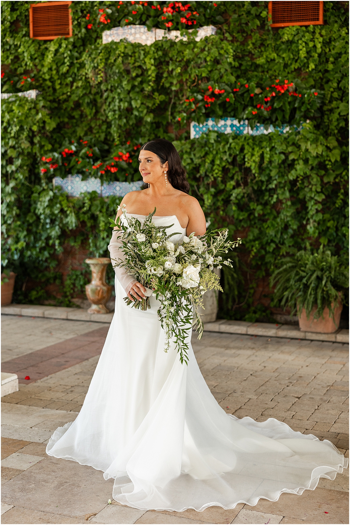 bridal portraits with wedding dress fanned out around her while she holds bouquet