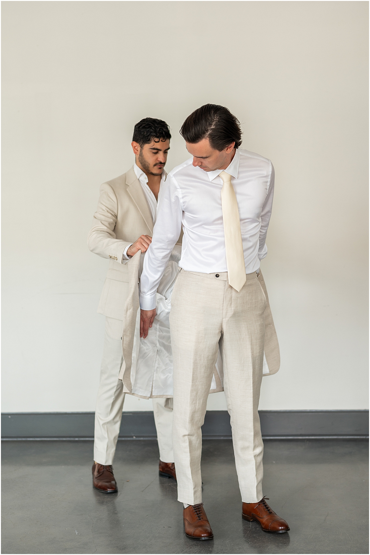 groom putting suit jacket on