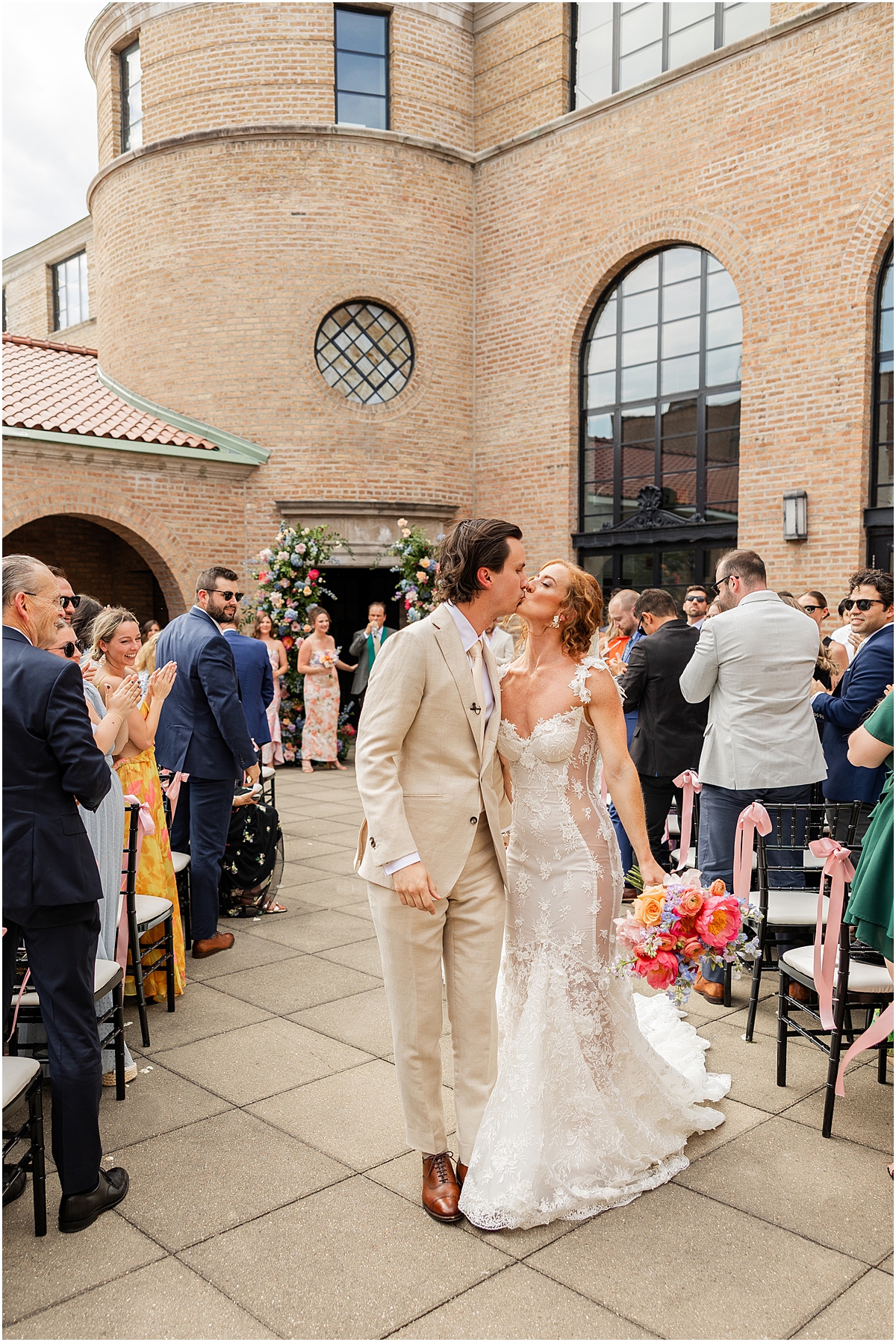 newlyweds kiss at Colorful Summer Wedding at Revel Motor Row in Chicago