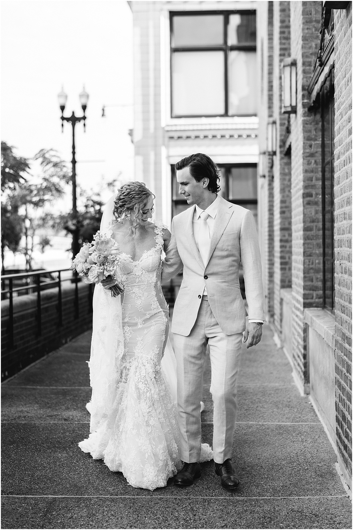 bride and groom walk together outside of Revel Motor Row in Chicago