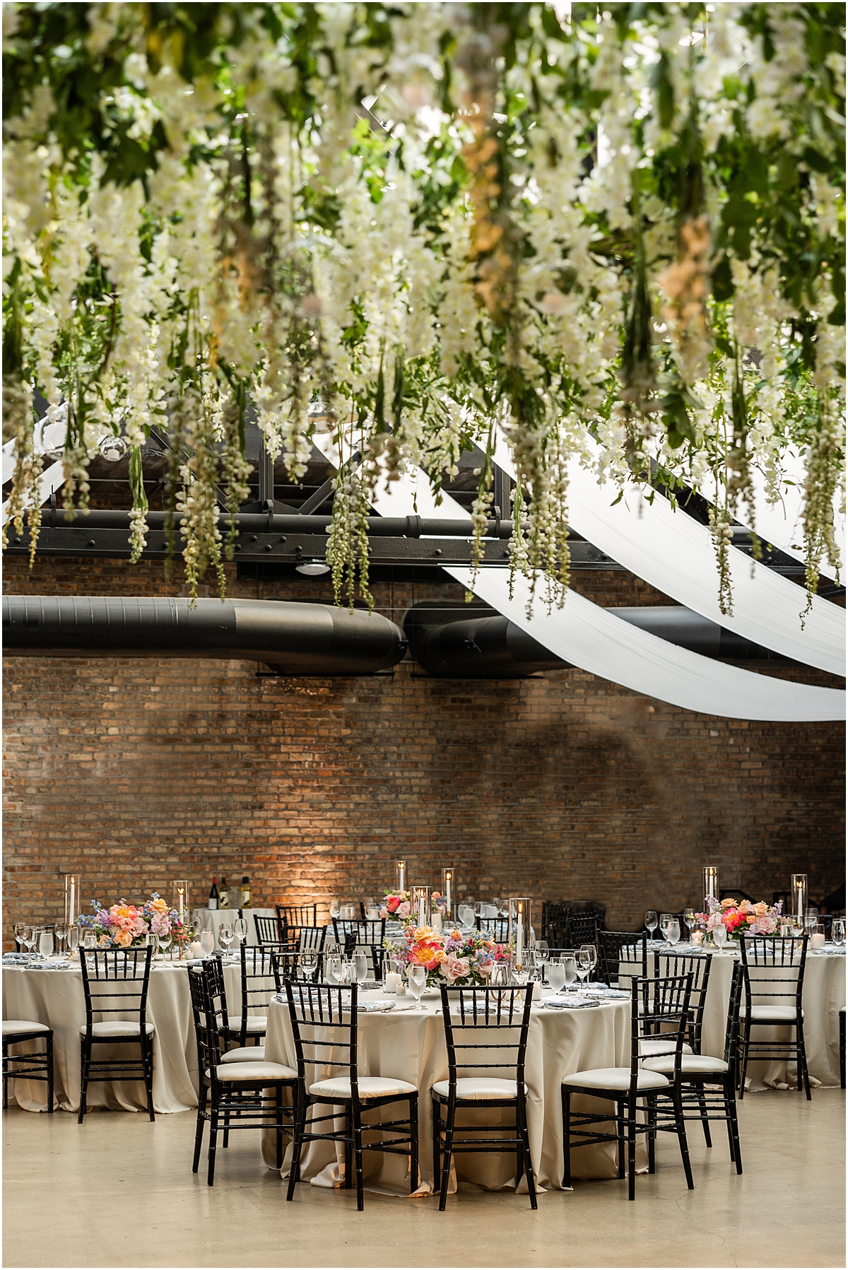 flowers and greenery hang from ceiling in Chicago venue, Revel Motor Row
