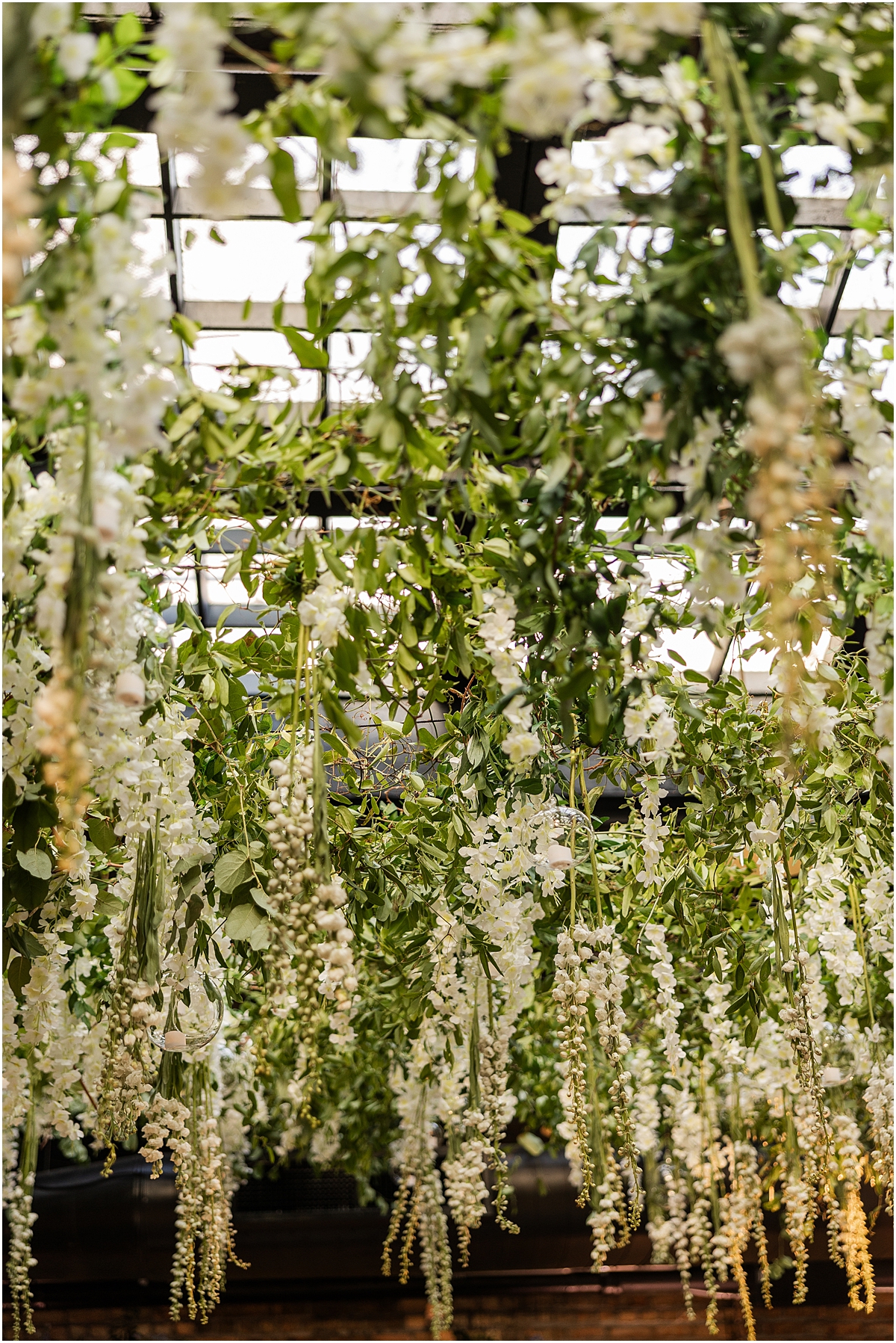 flowers and greenery hang from ceiling in Chicago venue, Revel Motor Row