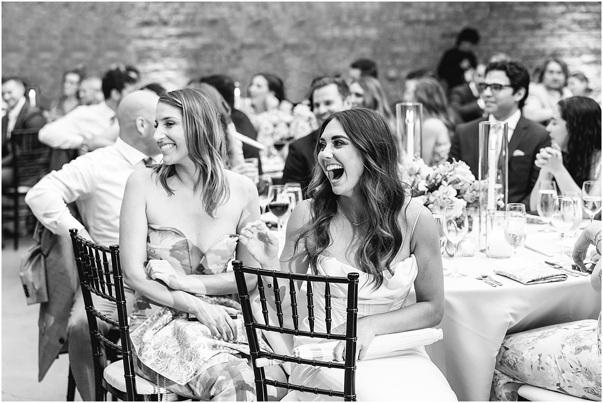 candid photo of guests laughing during wedding toasts