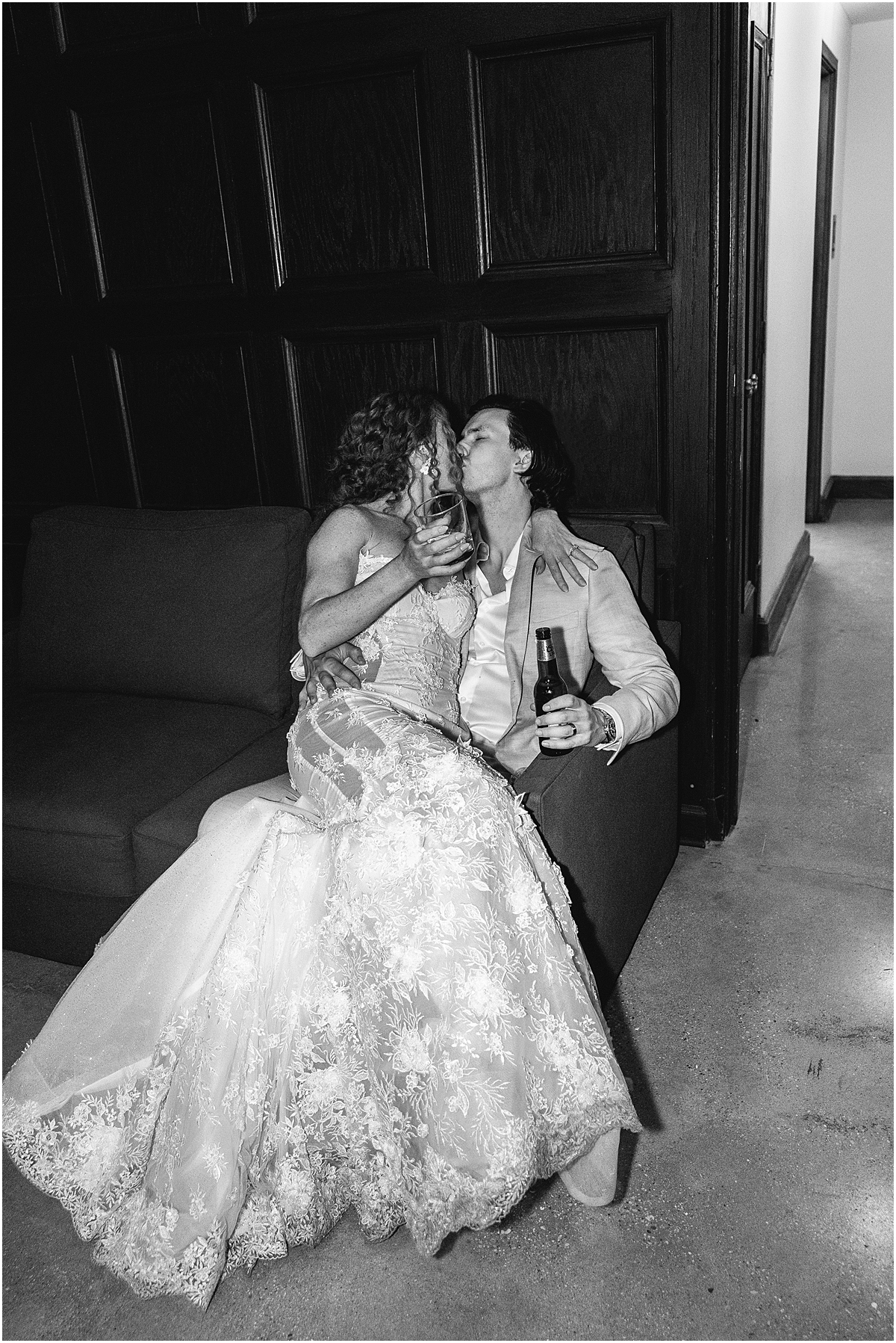 bride sits on grooms lap at the end of wedding night