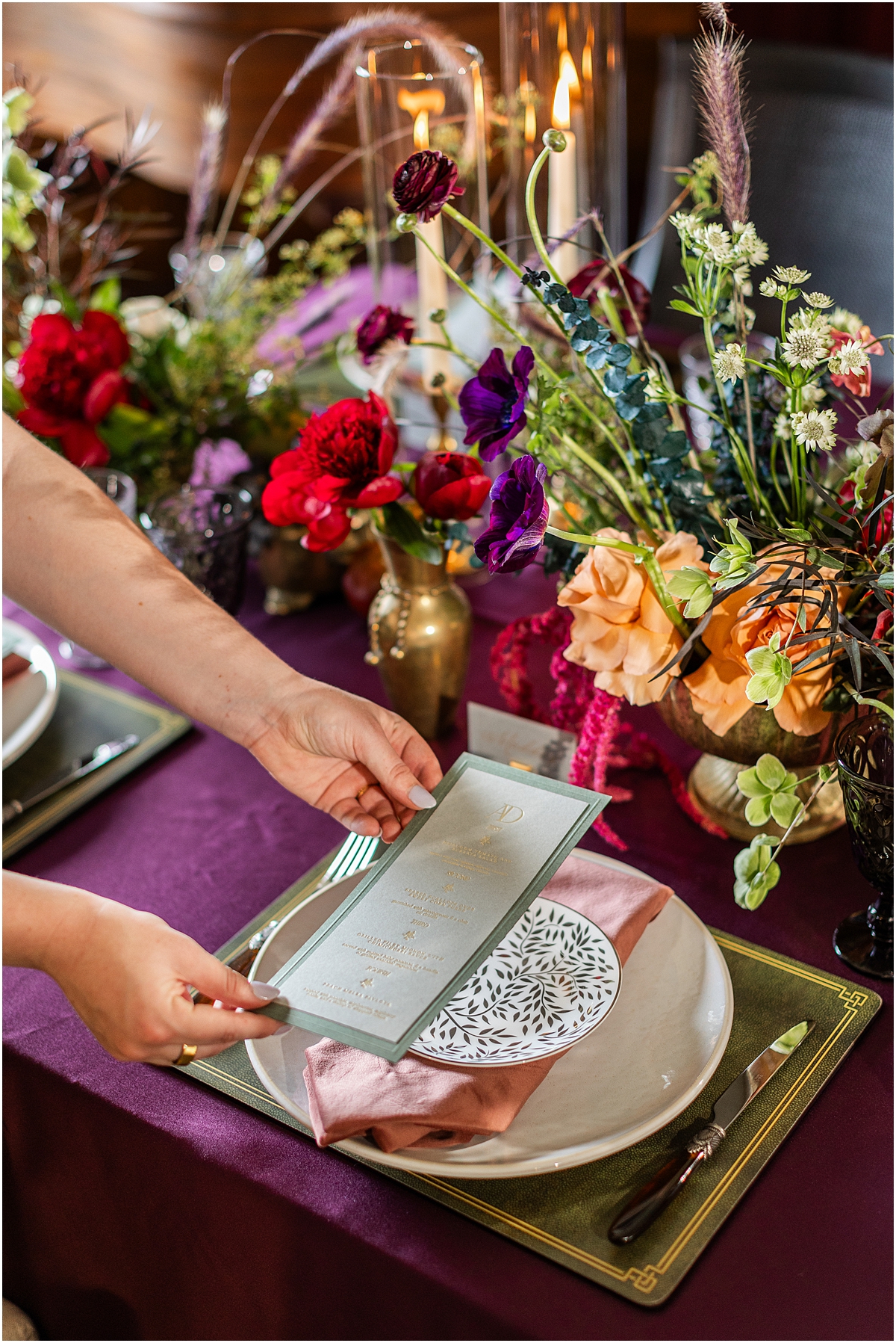 light green menu with dark green border being placed on patterned plate at place setting