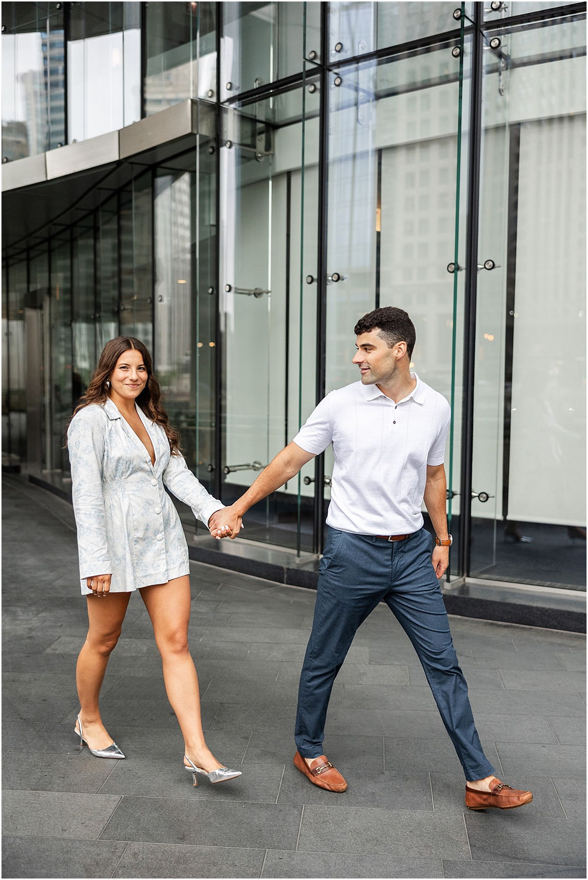 couple walk together holding hands during Downtown Chicago Engagement at Wrigley Building and Chicago Riverwalk