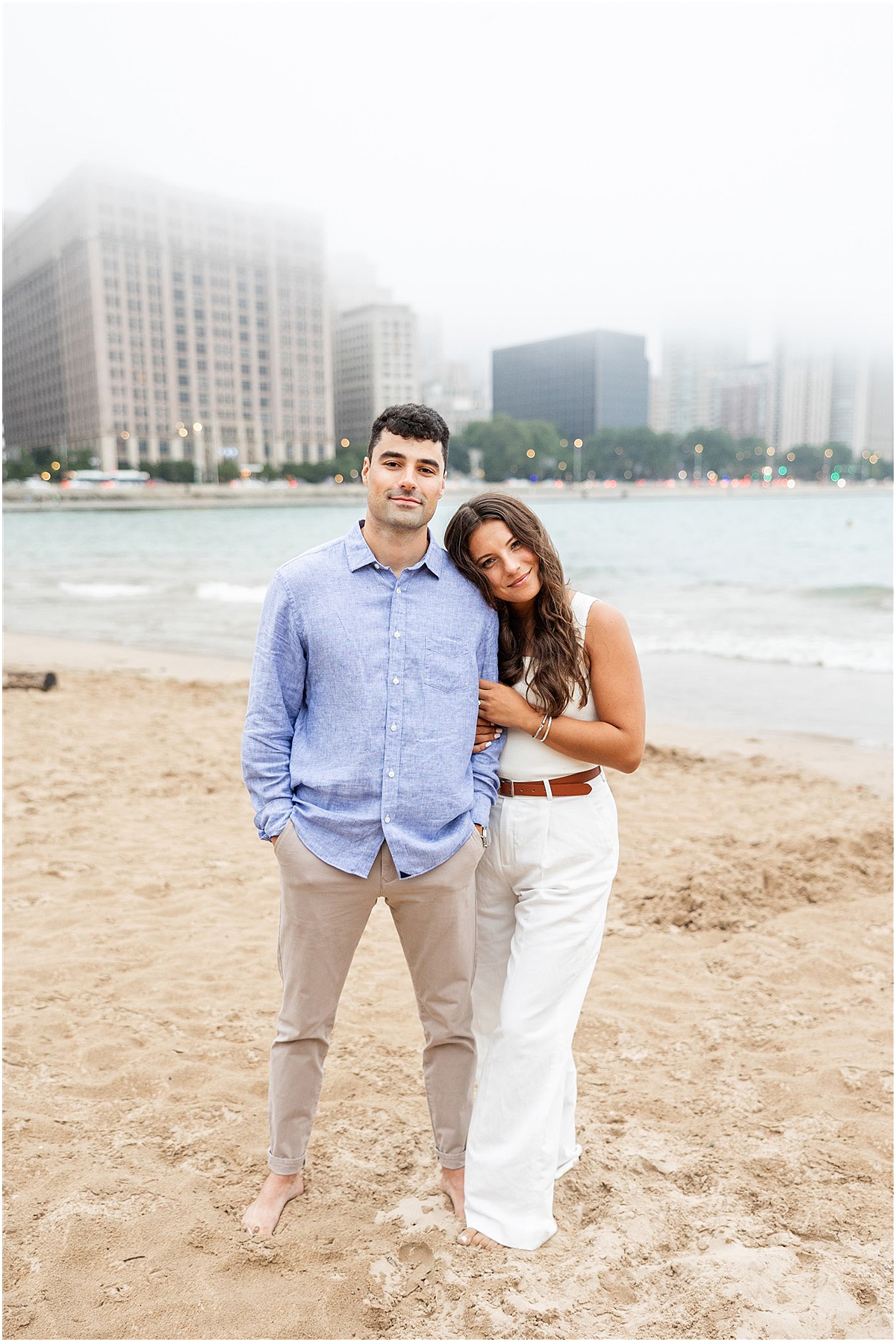 woman leans her head on man's shoulder during engagement