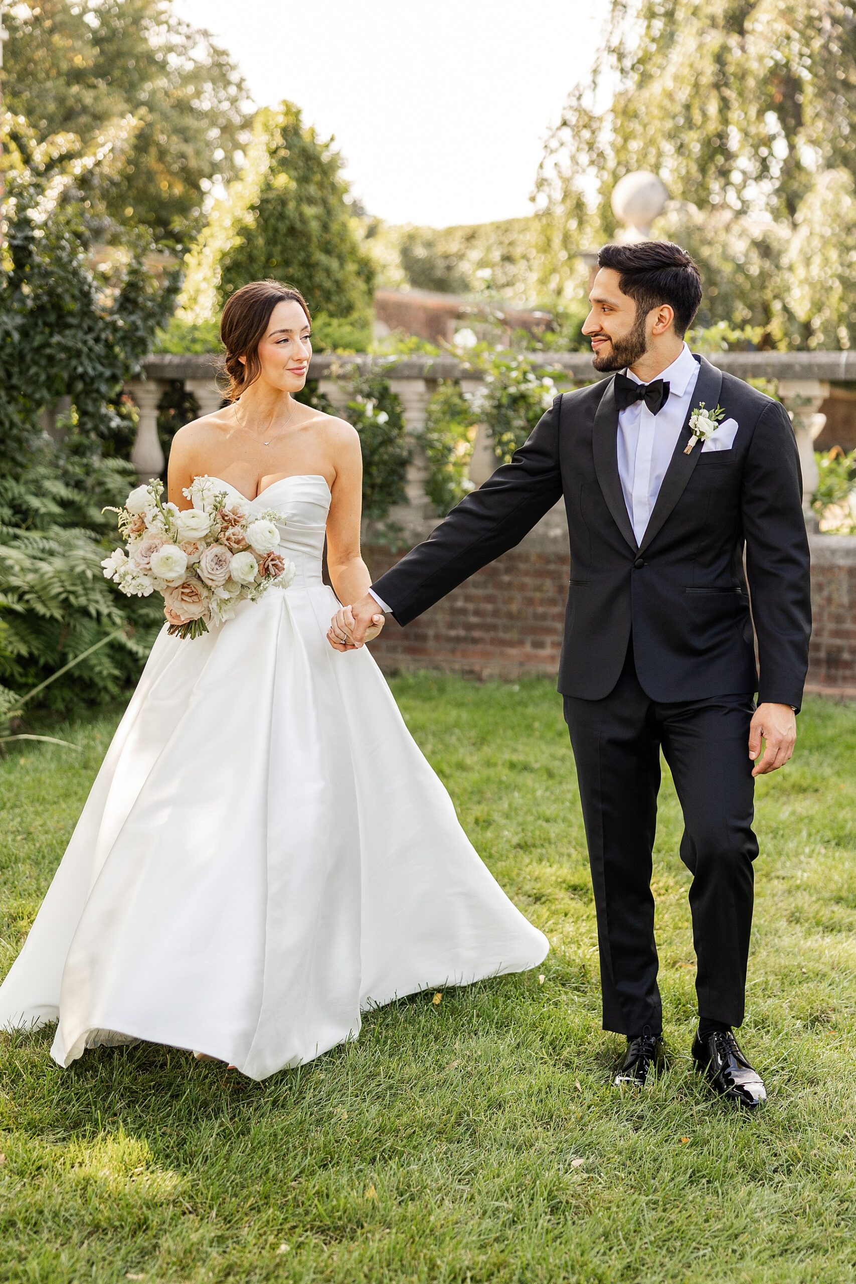 bride and groom photos in garden holding hands