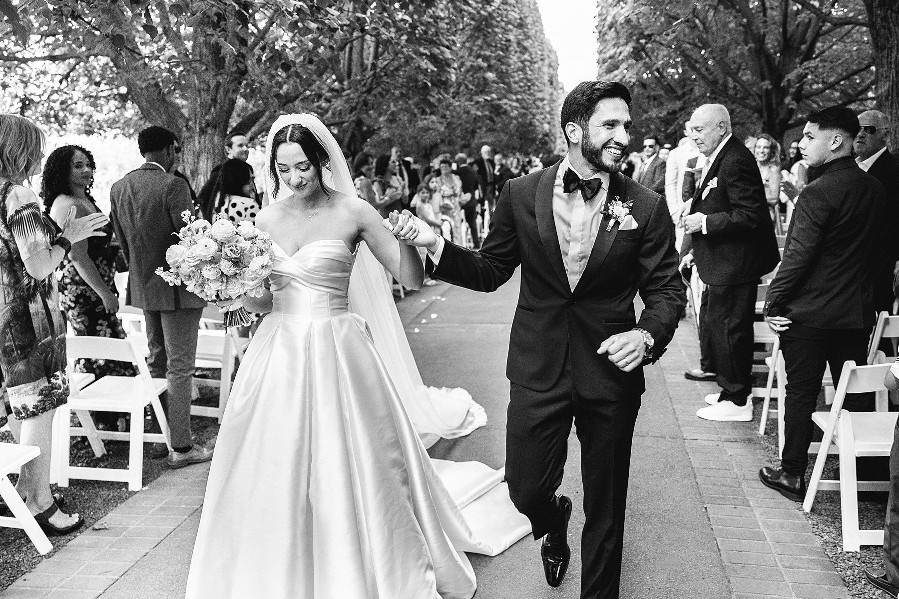 newlyweds exit wedding ceremony together holding hands