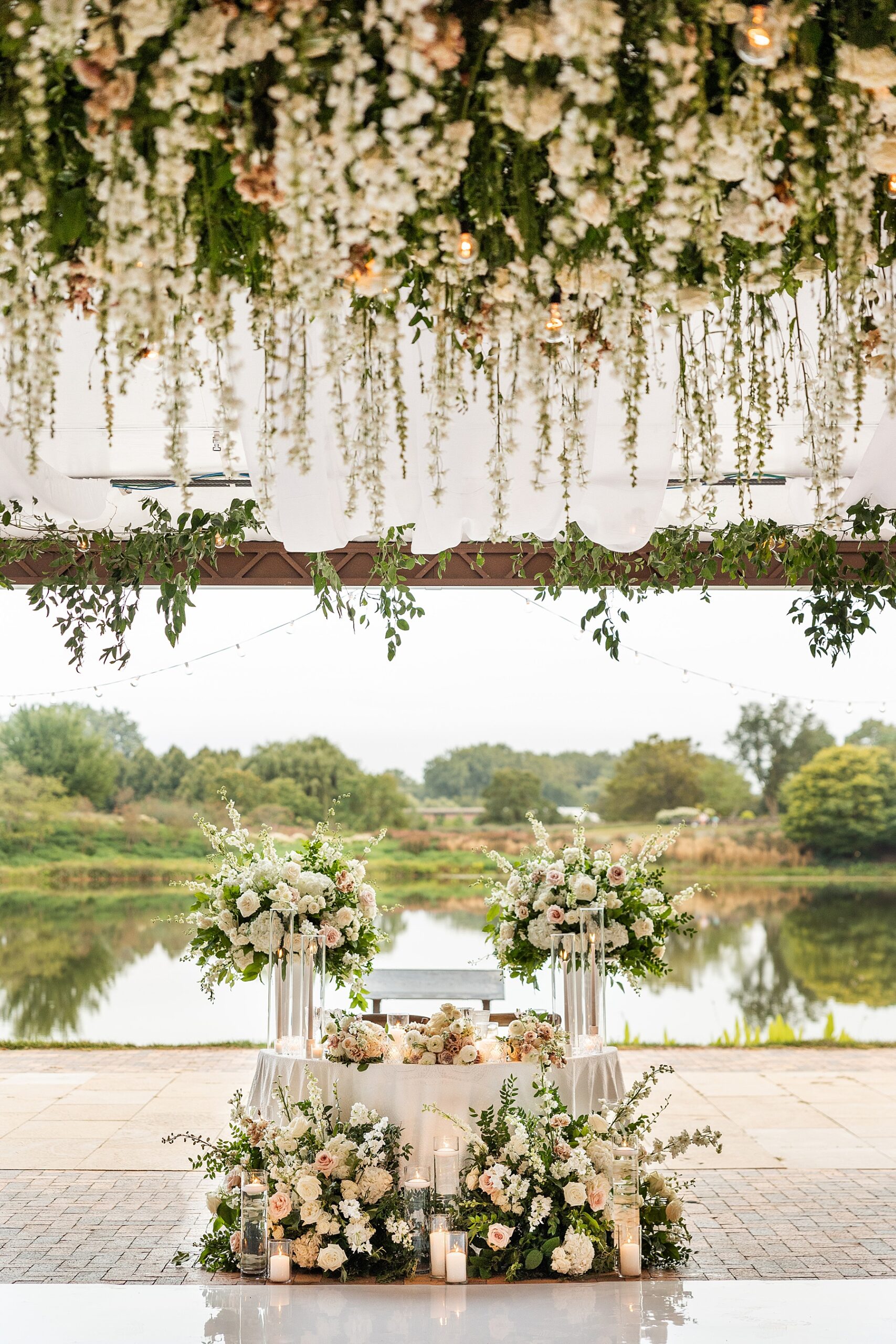 soft florals decorate the ceiling over the dance floor at wedding reception facing the water at Chicago Botanic Gardens  