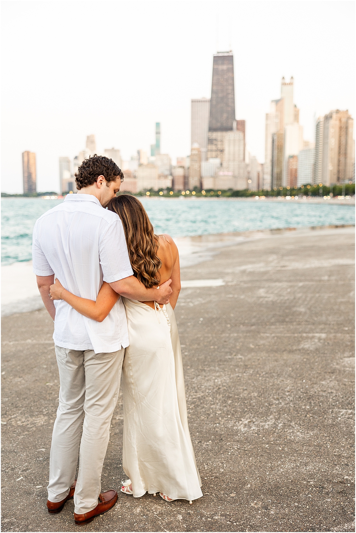 engaged couple at North Avenue Beach look at the Chicago Skyline