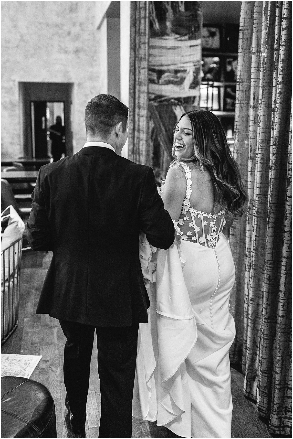 groom carries the back of bride's wedding dress