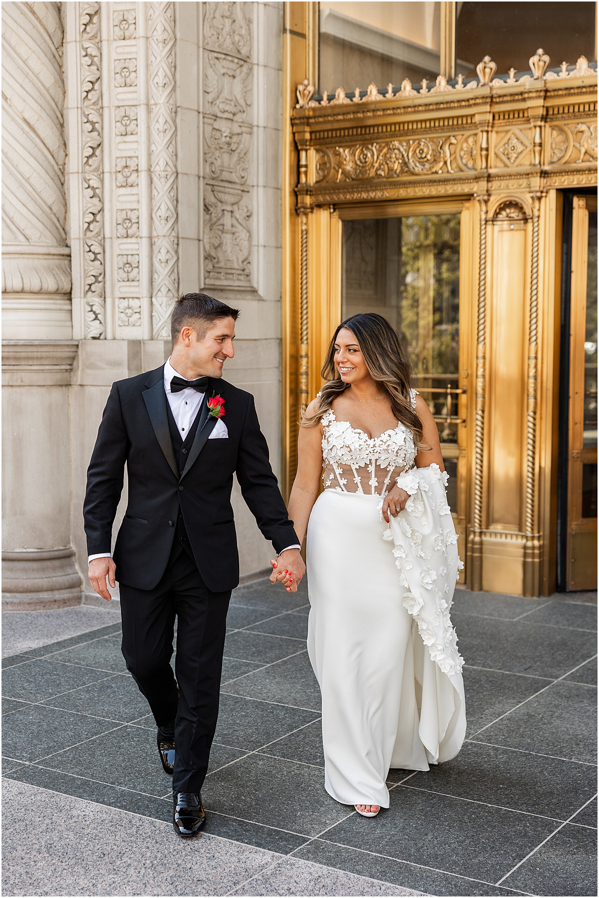 wedding portraits of bride and groom outside of gold doors of Wrigley Building 