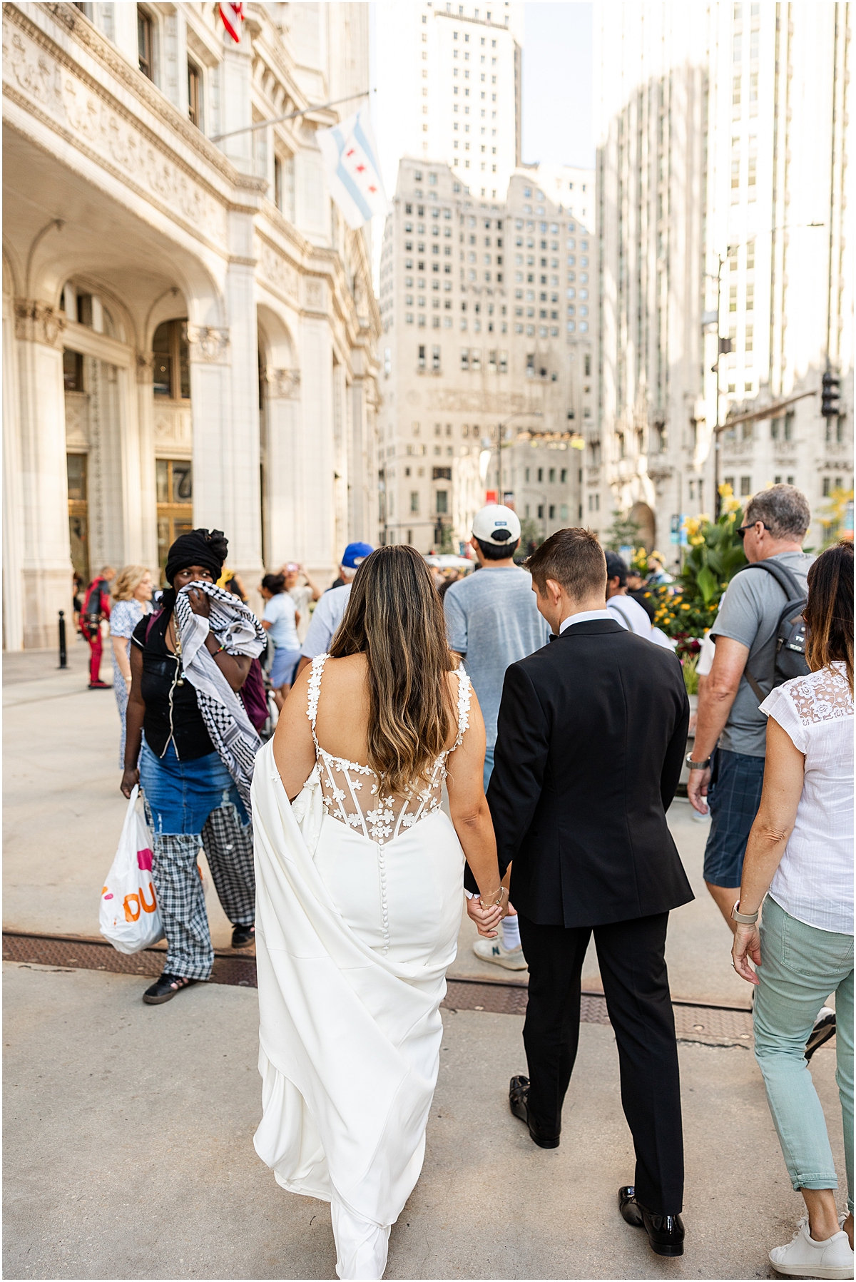 bride and groom walk together holding hands in downtown Chicago 