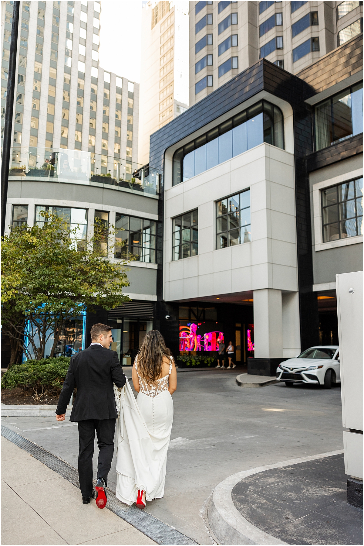 bride and groom walk together showing off the red on bottom of shoes