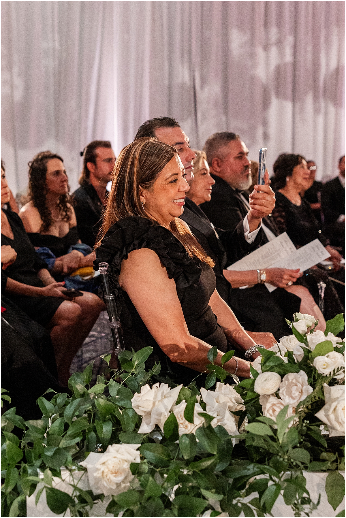 guests smile and laugh as they watch wedding ceremony 
