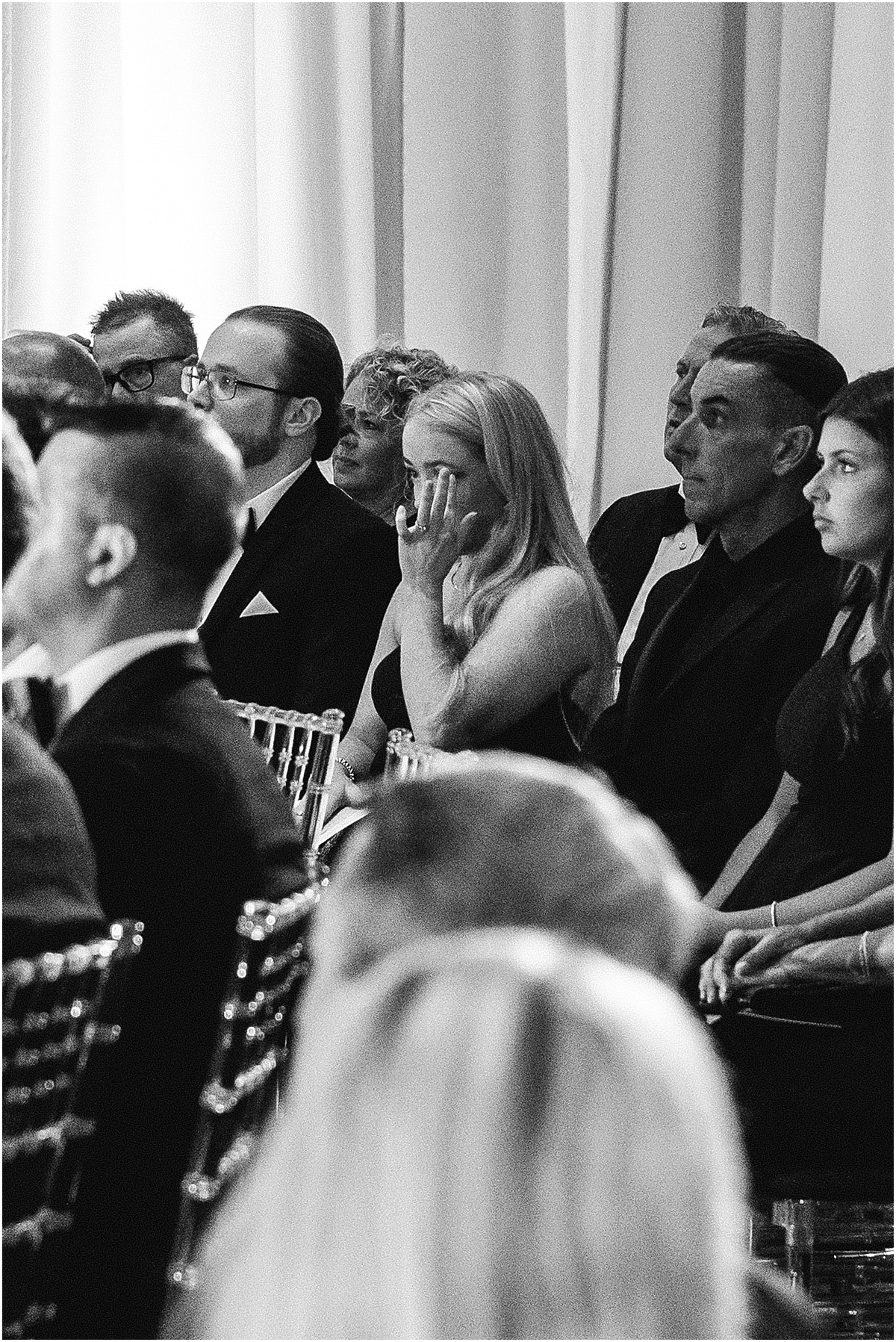 guests wipe away tears during wedding ceremony 