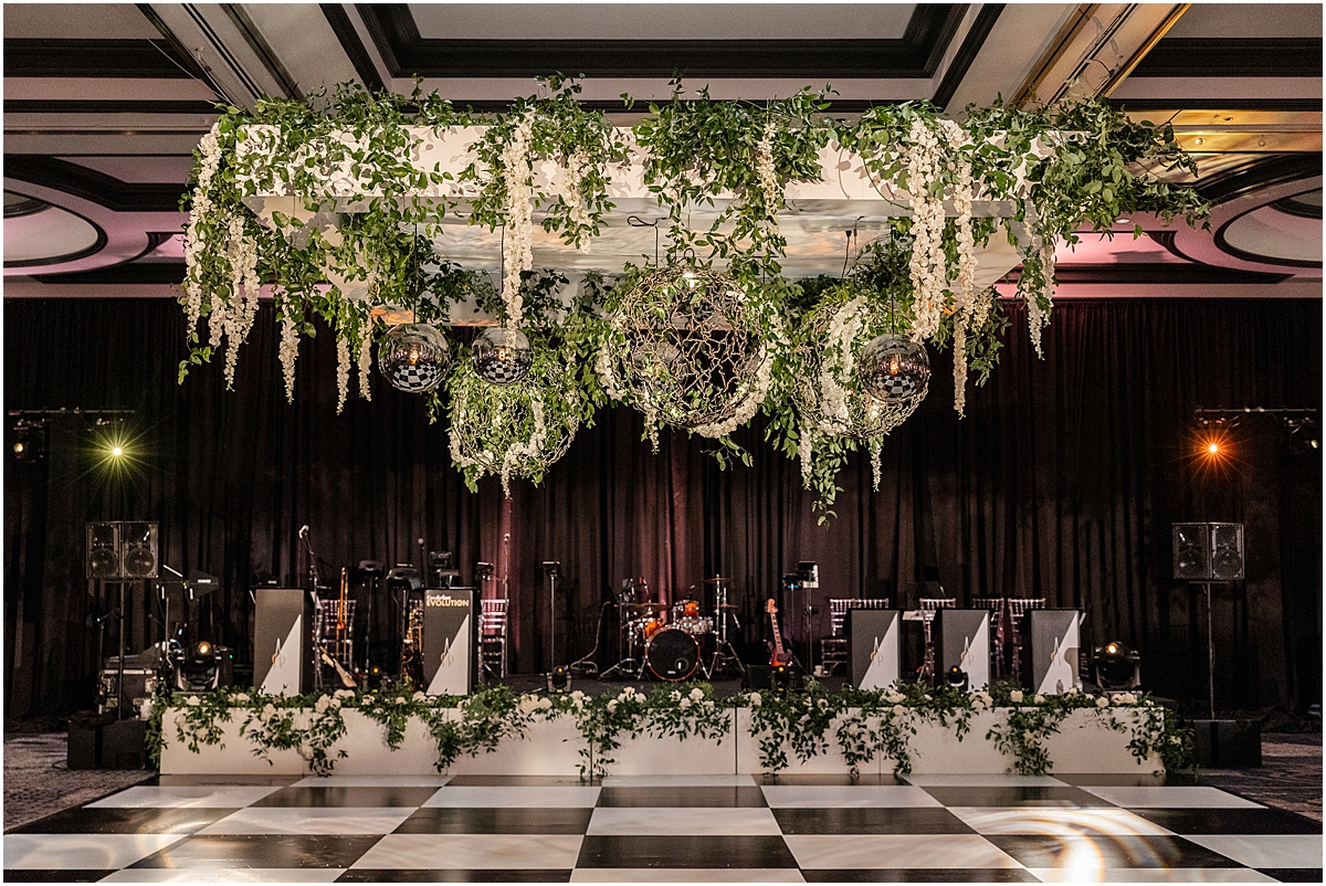 greenery draped from ceiling over black and white checkered dance floor